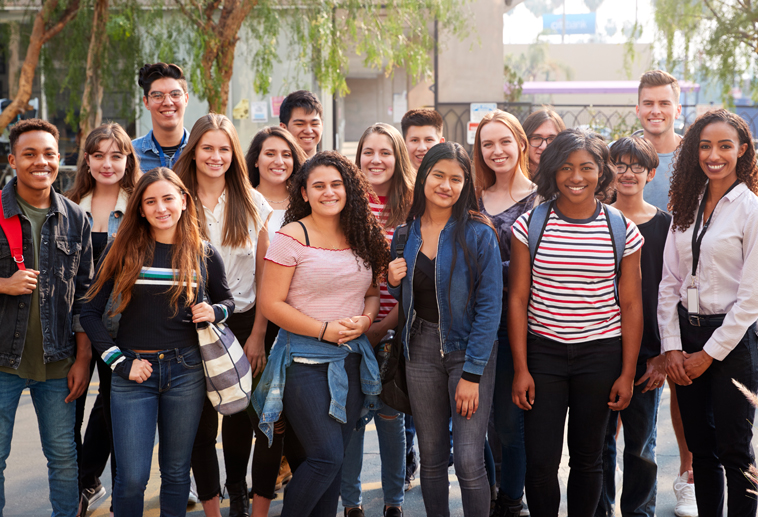 A group of teen students smiling for a photo.